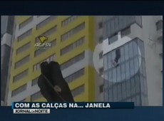 Homem fica pendurado em janela de prédio e é salvo na Rússia