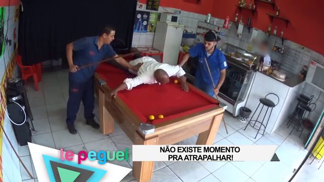 Homem debruçado sobre a mesa enquanto joga sinuca, ele se concentra no jogo,  se divertindo